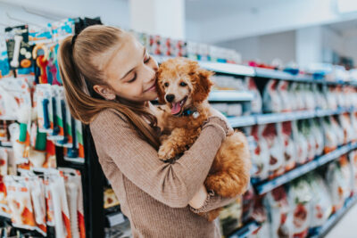 girl with her poodle puppy in pet shop