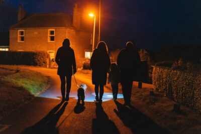 people walking at night with their dog