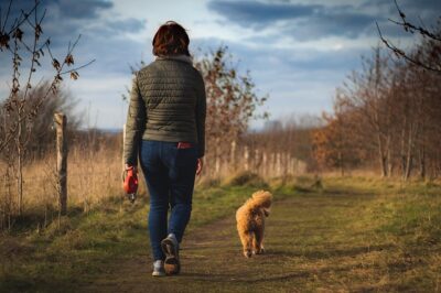 woman walking with her cavapoo dog
